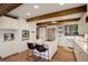 Bright kitchen featuring a center island, white brick wall, modern stainless appliances, and wooden floors at 34127 Cactus Dr, Evergreen, CO 80439