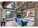Cozy living room with a stone fireplace, exposed beams, and scenic outdoor views at 34127 Cactus Dr, Evergreen, CO 80439