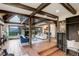 Inviting living room featuring exposed beams, stone fireplace, and scenic views from large windows at 34127 Cactus Dr, Evergreen, CO 80439