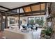 Bright living room with exposed beams, terracotta tile flooring, and views of the lush outdoors at 34127 Cactus Dr, Evergreen, CO 80439