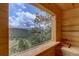 Scenic view from inside the sauna, highlighting the wooded landscape and natural light at 34127 Cactus Dr, Evergreen, CO 80439