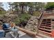 Backyard cascading rock waterfall feature with natural landscaping and inviting patio space at 34127 Cactus Dr, Evergreen, CO 80439