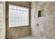 Close-up of a tile shower with a frosted glass block window at 1356 Carlyle Park Cir, Highlands Ranch, CO 80129