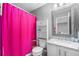 Bathroom with pink shower curtain, updated vanity, and decorative mirror at 715 Mockingbird St, Brighton, CO 80601