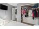 A bedroom featuring a spacious closet, television, and convenient access to the laundry room at 715 Mockingbird St, Brighton, CO 80601