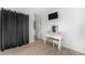 Bedroom with a vanity and television, wood flooring, and adjacent access to the laundry at 715 Mockingbird St, Brighton, CO 80601
