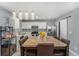 Open-concept kitchen with stainless steel appliances and a dining area with modern pendant lights at 715 Mockingbird St, Brighton, CO 80601