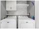 A functional laundry room with two modern Maytag washer-dryer units and ample storage at 715 Mockingbird St, Brighton, CO 80601