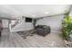 Contemporary living room with sleek gray floors, modern furniture, a white staircase and vibrant plants adorning the walls at 715 Mockingbird St, Brighton, CO 80601