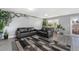 Inviting living room with modern gray flooring, stylish rug, and walls adorned with lush green climbing plants at 715 Mockingbird St, Brighton, CO 80601