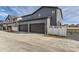 Two-car gray garage with white fence and spacious driveway at 1288 S Algonquian St, Aurora, CO 80018