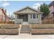 Charming gray brick home with mature landscaping, decorative brick planter beds and inviting front porch at 764 S Corona St, Denver, CO 80209