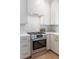 Modern kitchen featuring stainless steel appliances, gas range, and stylish tile backsplash at 764 S Corona St, Denver, CO 80209