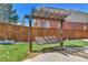 Backyard swing set with wooden pergola, lush grass, and partial privacy fence at 20948 E Hamilton Ave, Aurora, CO 80013