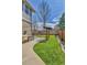 Landscaped backyard featuring a swing set, mature trees, stone walls, and lush lawn at 20948 E Hamilton Ave, Aurora, CO 80013