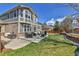 Backyard features a well-kept lawn, patio, an outdoor dining area, and lush landscaping at 20948 E Hamilton Ave, Aurora, CO 80013