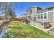 The backyard features a well-kept lawn, patio, hot tub, and lush landscaping at 20948 E Hamilton Ave, Aurora, CO 80013