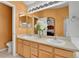 Bathroom featuring double sinks, honey colored wood cabinets, and a large mirror at 20948 E Hamilton Ave, Aurora, CO 80013
