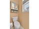 Cozy bathroom featuring a toilet, decorative storage above, and a bright window at 20948 E Hamilton Ave, Aurora, CO 80013