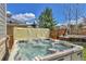Backyard featuring a hot tub with clear water, wooden fence, and beautiful landscaping at 20948 E Hamilton Ave, Aurora, CO 80013