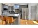 Spacious kitchen with island, granite counters, stainless appliances, gray cabinets, and hardwood flooring for a modern look at 20948 E Hamilton Ave, Aurora, CO 80013
