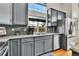 Well-lit kitchen features gray cabinetry, granite countertops, stainless steel appliances, and a double basin sink at 20948 E Hamilton Ave, Aurora, CO 80013