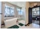Bathroom featuring a stand-alone tub, glass shower, and dark trim at 23774 E 36Th Pl, Aurora, CO 80019