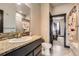 Bathroom with granite countertops, a mirror, a shower, and an open doorway to a bedroom at 23774 E 36Th Pl, Aurora, CO 80019