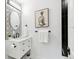 Stylish powder room with a geometric accent wall, oval mirror, and modern fixtures adding a touch of elegance at 3519 S Holly St, Denver, CO 80237