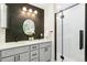 Beautiful bathroom with modern vanity, herringbone accent wall, and glass enclosed shower at 3519 S Holly St, Denver, CO 80237