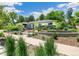 Landscaped front yard featuring a walkway, stone walls, and vibrant plantings at 3519 S Holly St, Denver, CO 80237