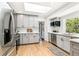 Bright kitchen with grey cabinets, stainless steel appliances, and hardwood floors at 3519 S Holly St, Denver, CO 80237