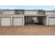 View of townhouse garages with an open carport for parking and ample storage at 544 Vance St, Lakewood, CO 80226