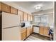 Bright kitchen featuring wood cabinets, white countertops, and vinyl flooring at 3415 S Ammons St # 24-2, Lakewood, CO 80227