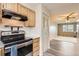 A stainless steel stove sits next to cabinets and an open doorway to the living room at 3415 S Ammons St # 24-2, Lakewood, CO 80227