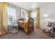 Cozy Bedroom with a wooden crib, natural light, striped accent wall and a comfortable rocking chair at 673 N Tempe St, Aurora, CO 80018