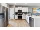 Stylish kitchen with white cabinetry, stainless steel appliances, and ample counter space, designed for both functionality and aesthetics at 673 N Tempe St, Aurora, CO 80018