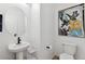 Modern powder room with a pedestal sink, round mirror, and artwork, enhanced by neutral tones at 673 N Tempe St, Aurora, CO 80018