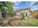 Backyard with patio, garden beds, mature trees, and a brick home exterior at 3024 W Denver Pl, Denver, CO 80211
