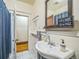 Cozy bathroom features a pedestal sink, decorative mirror, and tiled floors at 3024 W Denver Pl, Denver, CO 80211