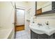 Classic bathroom with tiled floors, a pedestal sink, and a vintage medicine cabinet at 3024 W Denver Pl, Denver, CO 80211