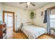 Bright bedroom with hardwood floors and natural wood trim around doorway and window at 3024 W Denver Pl, Denver, CO 80211