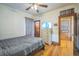 Bedroom features hardwood floors, gray bedding, ceiling fan and natural wood trim at 3024 W Denver Pl, Denver, CO 80211