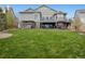 Large backyard with lush lawn, patio, fire pit, and hot tub provides ample space for outdoor enjoyment at 5310 Craftsman Dr, Parker, CO 80134