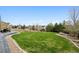 Lush green backyard with mature trees, rock lined flowerbeds, and open space for activities at 5310 Craftsman Dr, Parker, CO 80134