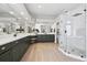 Elegant bathroom featuring double vanity, glass shower, decorative mirrors, and modern fixtures at 5310 Craftsman Dr, Parker, CO 80134