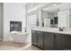 Modern bathroom with a freestanding tub, sleek vanity, and a fireplace, all brightly lit at 5310 Craftsman Dr, Parker, CO 80134