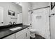 Modern bathroom featuring sleek, black hardware, a shower with white tile, and a black marble countertop at 5310 Craftsman Dr, Parker, CO 80134