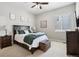 Cozy bedroom features neutral decor, a ceiling fan, and a dark wood-trimmed bedframe and dresser at 5310 Craftsman Dr, Parker, CO 80134