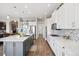 Bright kitchen features white cabinets, stainless steel appliances, large island, and wood floors at 5310 Craftsman Dr, Parker, CO 80134